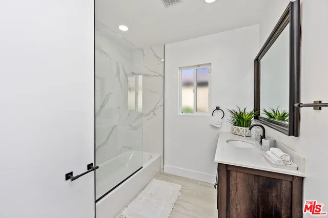 a bathroom with a shower sink and mirror