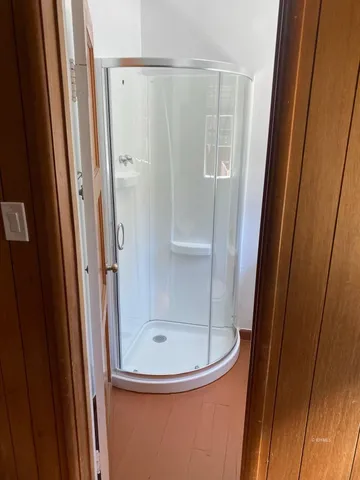 a bathroom with a glass shower door and a sink