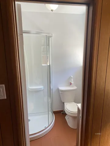 a bathroom with a toilet and a shower