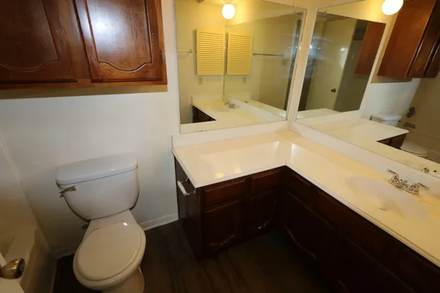 an empty room with windows and chandelier fan