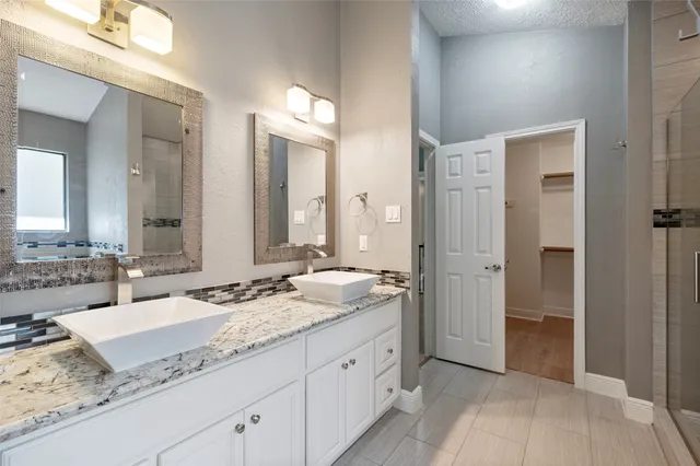 a spacious bathroom with a granite countertop sink and a mirror