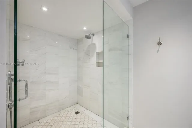 a bathroom with a shower and a glass door