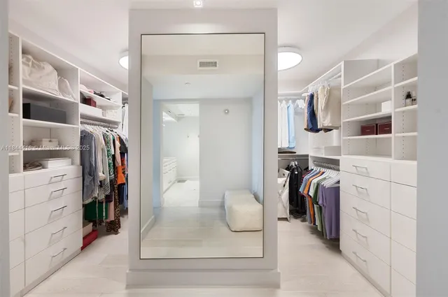 a view of walk in closet with clothes and shoes