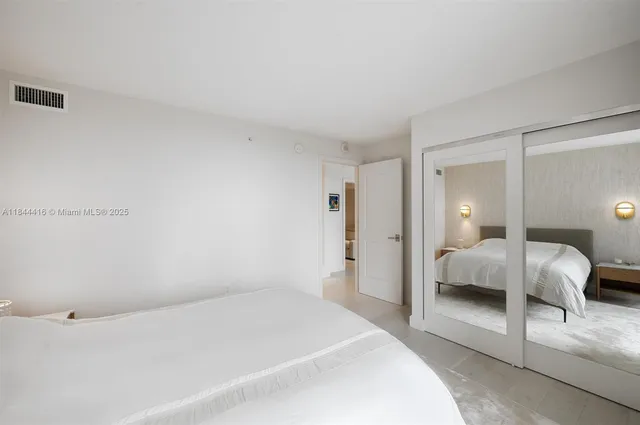 a bedroom with a bed and a white cabinet