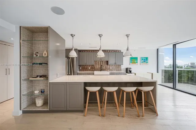 a kitchen with a sink and chairs