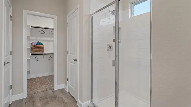 a spacious bedroom with a bed a couch and a chandelier