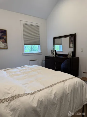 a bedroom with a bed and a large window