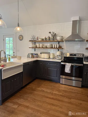 a kitchen with stainless steel appliances granite countertop a stove a sink and a refrigerator