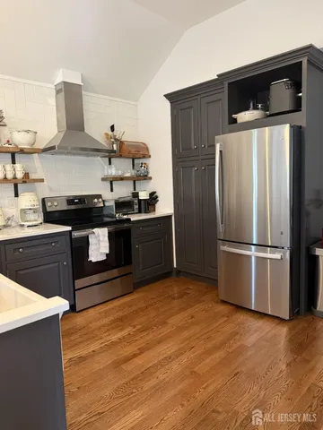 a kitchen with stainless steel appliances granite countertop a refrigerator and a stove