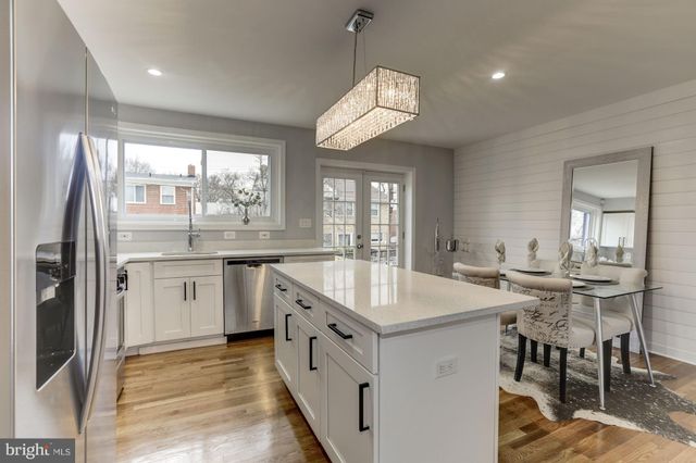 a kitchen with white cabinets and sink