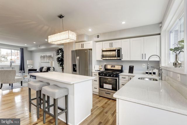 a kitchen with a sink a stove and chairs