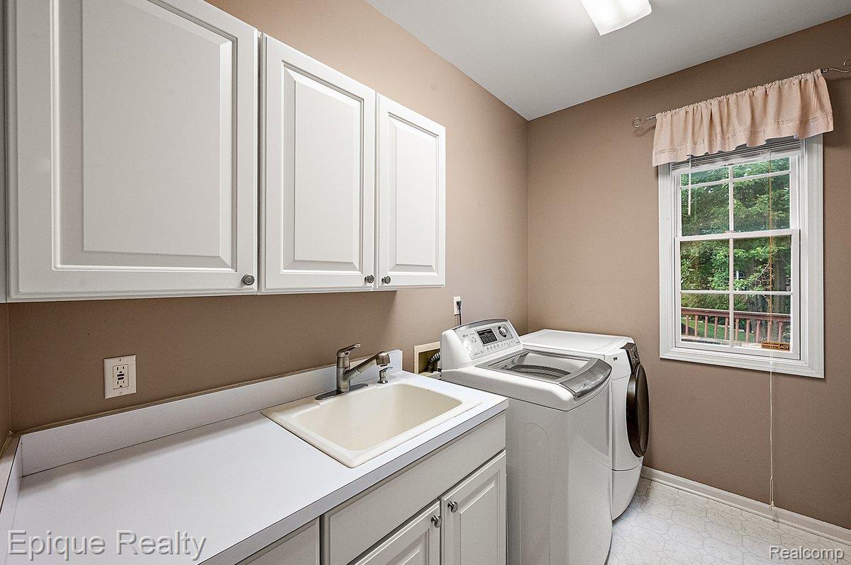 1909 Catlin Drive Rochester, MI 48306 - Photo 47 of 76 Dedicated laundry area featuring white shaker-style cabinetry, a utility sink with a chrome faucet, and a spacious countertop