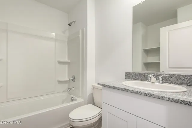 a bathroom with a granite countertop sink a toilet and shower