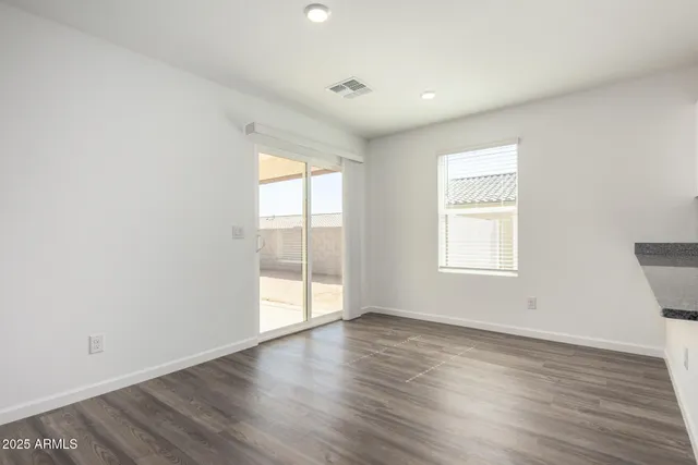 a kitchen with stainless steel appliances wooden floor and large window
