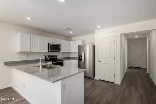a kitchen with stainless steel appliances granite countertop a refrigerator and a sink