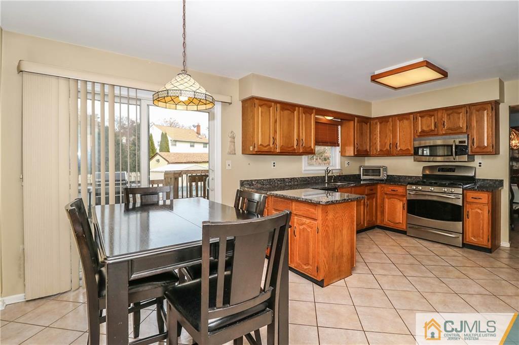 7 Paddock Court Edison, NJ 08820 - Photo 10 of 23 a kitchen with stainless steel appliances granite countertop a stove a sink dishwasher and a refrigerator with wooden cabinets