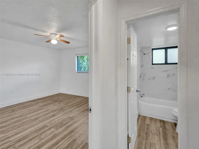 a view of a livingroom with a hardwood floor and a ceiling fan