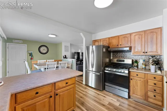 a kitchen with granite countertop a stove cabinets and refrigerator