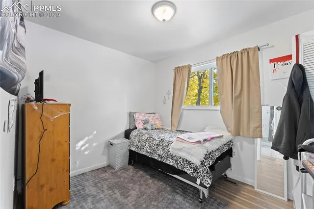 a bedroom with a bed and a flat tv screen on the dresser