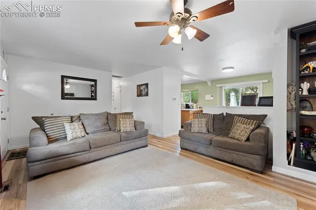 a living room with furniture and a ceiling fan