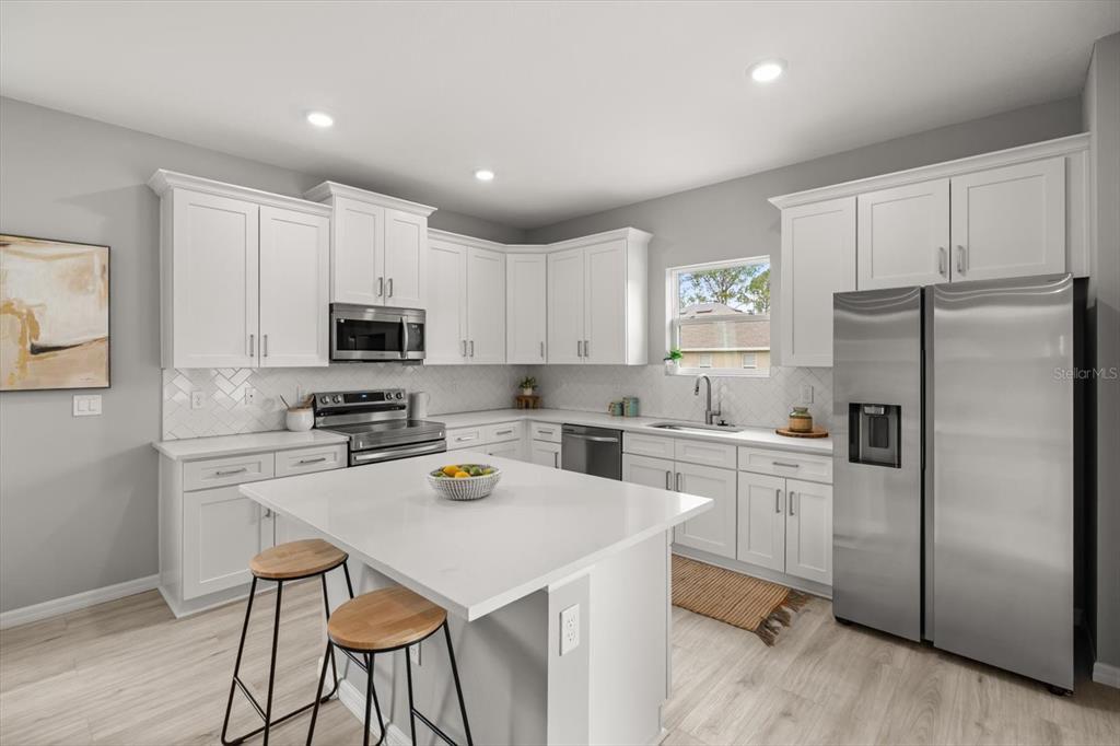 6143 Monegro Street Sebring, FL 33872 - Photo 5 of 25 a kitchen with a refrigerator a stove cabinets and a sink