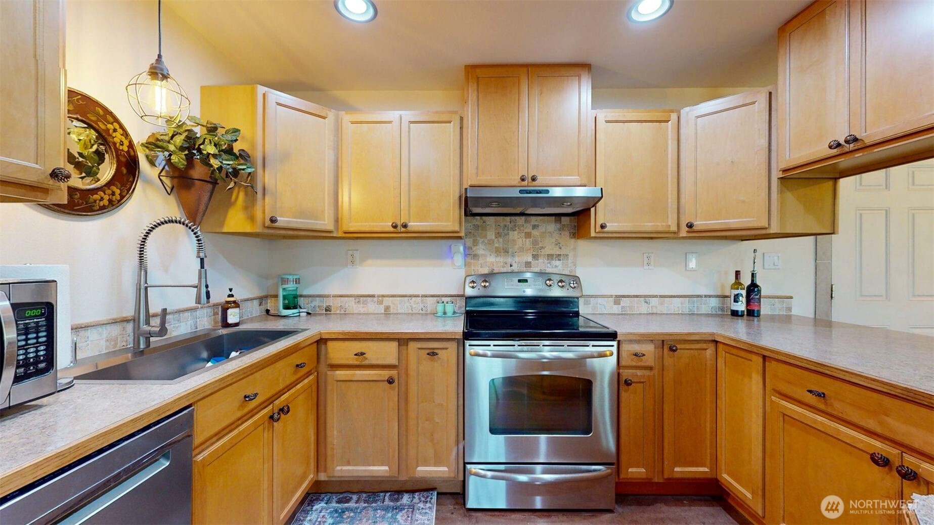 46 Shumway Road Omak, WA 98841 - Photo 12 of 40 a kitchen with kitchen island granite countertop a sink a stove and cabinets