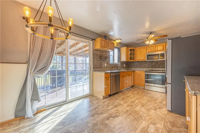 a kitchen with granite countertop a stove a sink and a refrigerator
