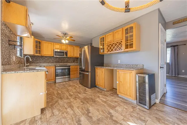 a kitchen with stainless steel appliances granite countertop a stove a sink and a refrigerator