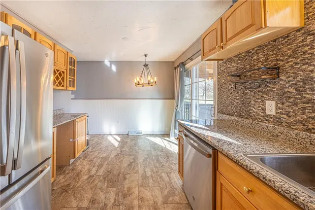 a kitchen with granite countertop a refrigerator and a sink