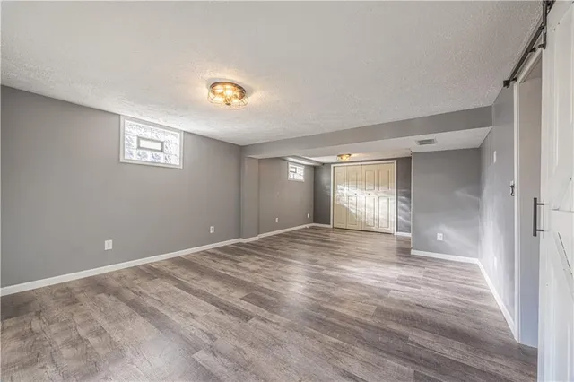 a view of an empty room with window and wooden floor