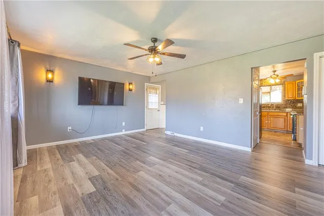 a view of an empty room with window and wooden floor