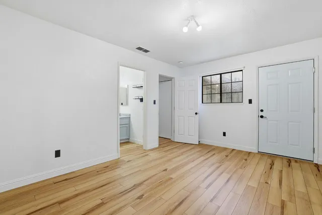 a view of an empty room with wooden floor