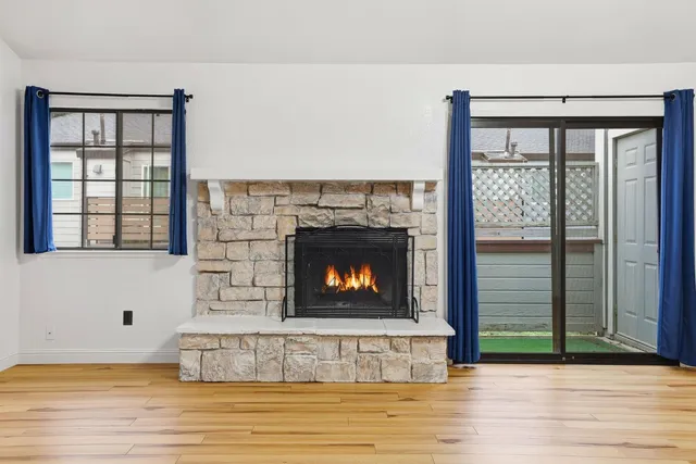 a living room with a fireplace and a floor to ceiling window