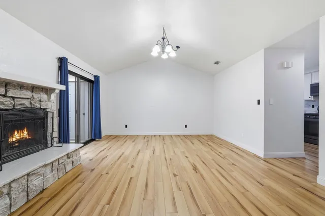 a view of empty room with wooden floor and fireplace