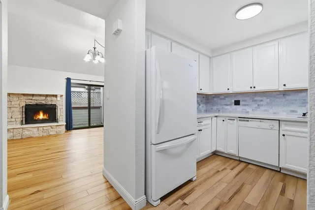 a kitchen with granite countertop white cabinets and white appliances