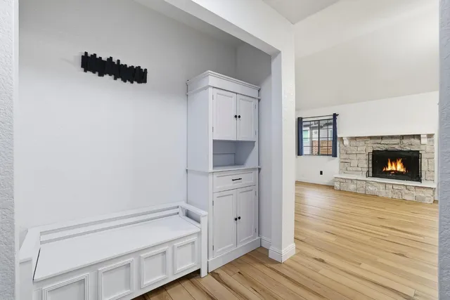 a hallway with white cabinets and wooden floor