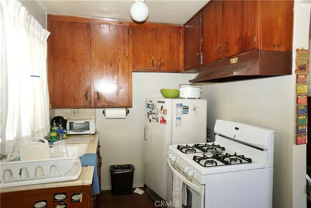 a kitchen with a refrigerator and a stove top oven
