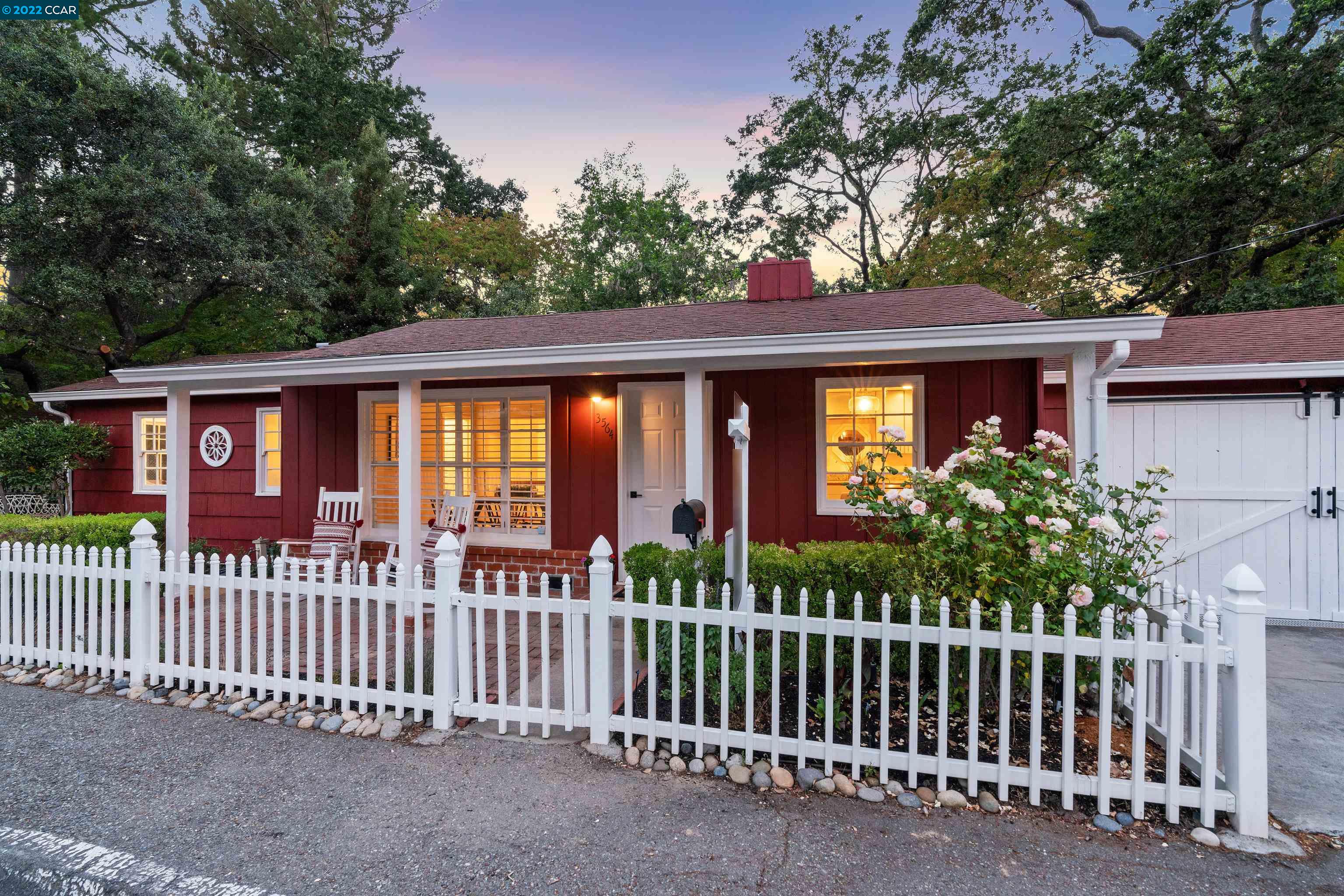 a view of a house with a small yard and wooden fence