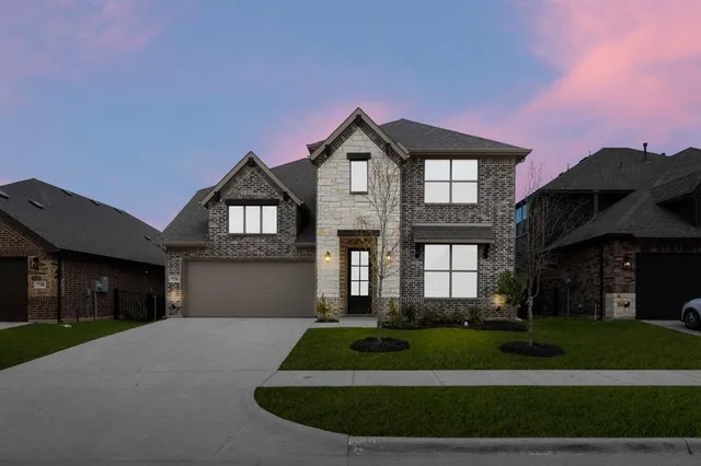 a front view of a house with a yard and garage