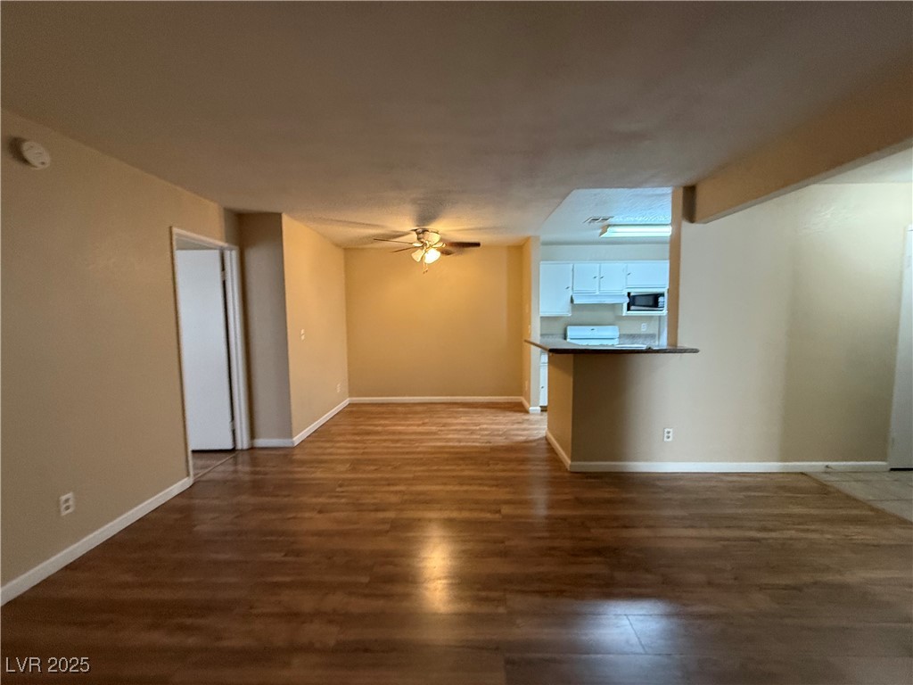 2200 South Fort Apache Road, Unit 1001 Las Vegas, NV 89117 - Photo 3 of 7 Unfurnished living room with dark wood-style floors and ceiling fan