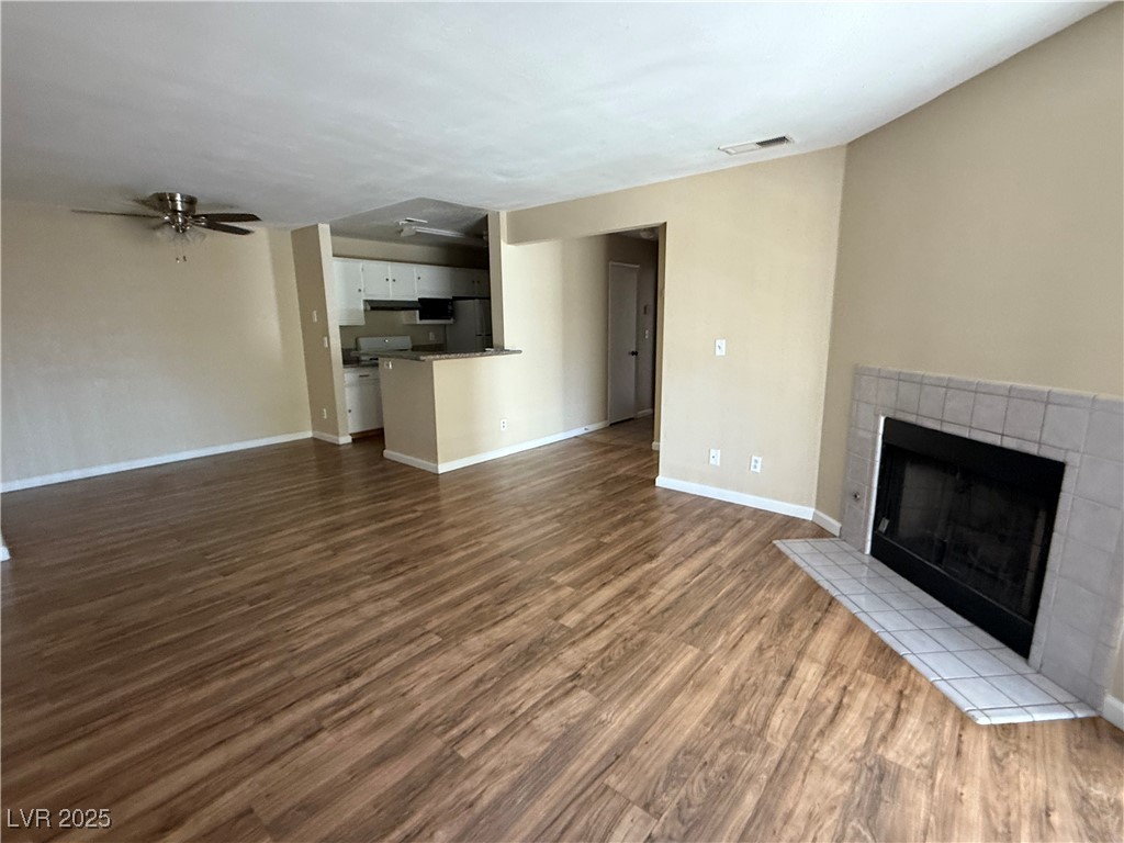 2200 South Fort Apache Road, Unit 1001 Las Vegas, NV 89117 - Photo 4 of 7 Unfurnished living room with a tile fireplace, dark wood-type flooring, and ceiling fan