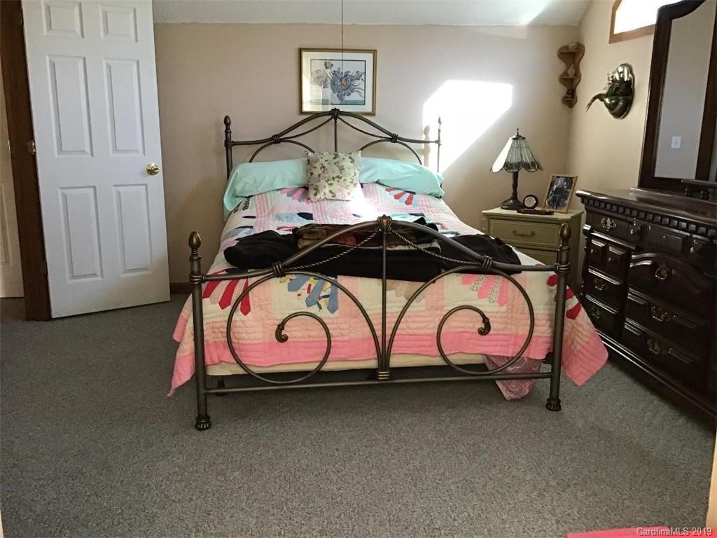 64 Squaw Ridge Road Waynesville, NC 28786 - Photo 22 of 32 a bedroom with a bed and a dresser