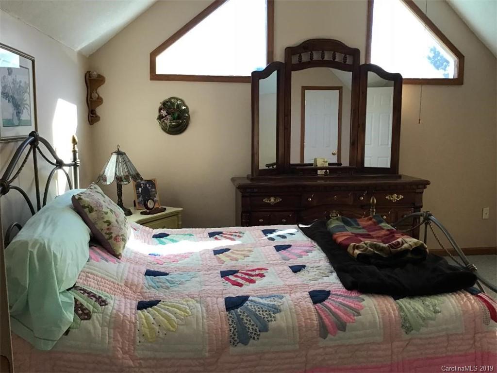 64 Squaw Ridge Road Waynesville, NC 28786 - Photo 23 of 32 a bedroom with a bed and a window