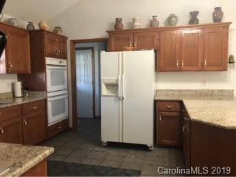64 Squaw Ridge Road Waynesville, NC 28786 - Photo 9 of 32 a kitchen with stainless steel appliances granite countertop a refrigerator and a stove