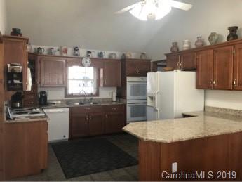 64 Squaw Ridge Road Waynesville, NC 28786 - Photo 10 of 32 a kitchen with a sink a stove and refrigerator
