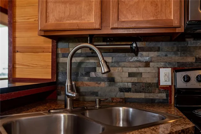 a kitchen with stainless steel appliances granite countertop a sink stove and cabinets