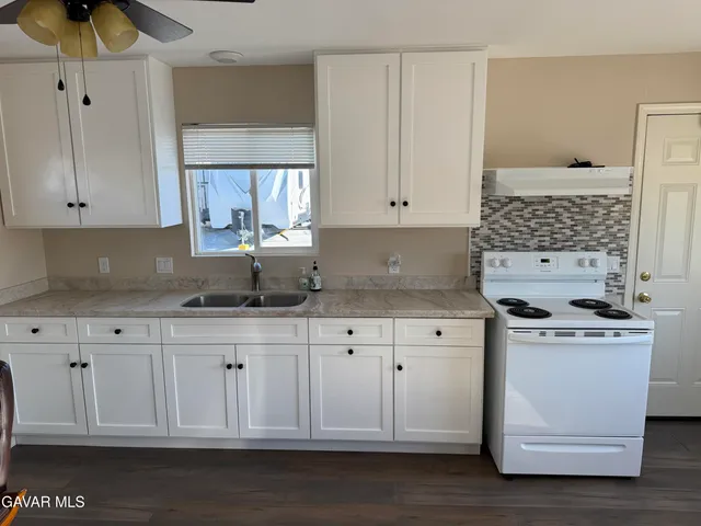 a kitchen with stainless steel appliances granite countertop a sink a stove and a granite counter tops