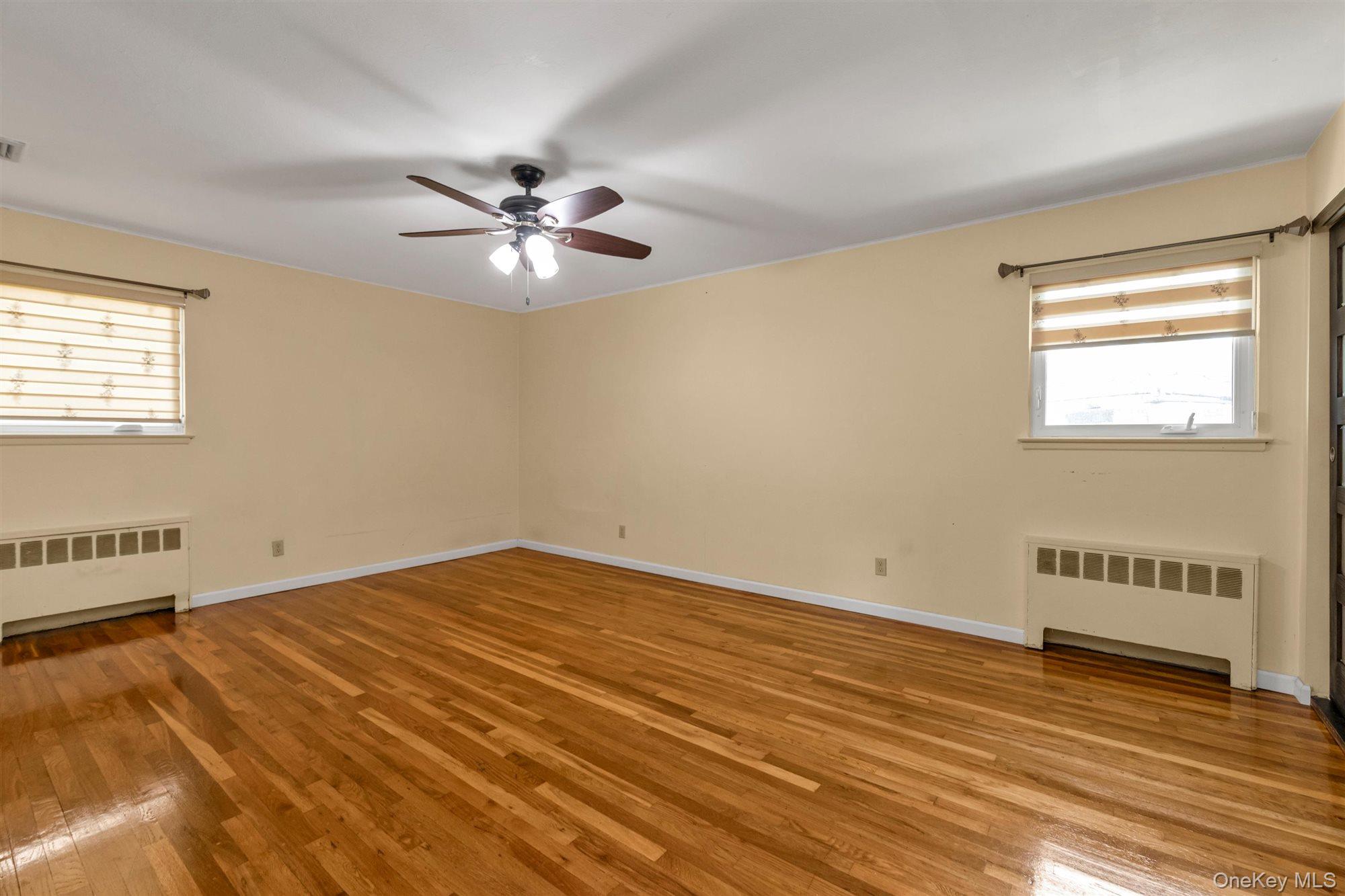 830 Pepperidge Road Westbury, NY 11590 - Photo 14 of 23 wooden floor in an empty room with a window
