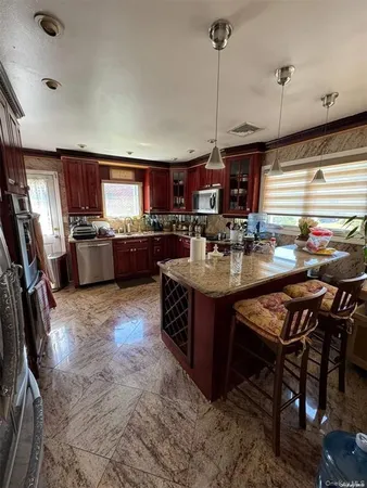 a kitchen with kitchen island a large counter top space appliances and cabinets