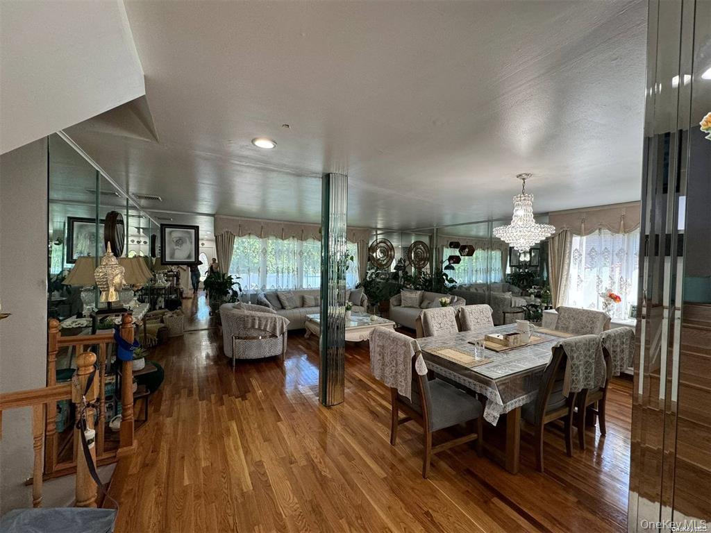 830 Pepperidge Road Westbury, NY 11590 - Photo 8 of 15 a living room with furniture dining table a large window and wooden floor